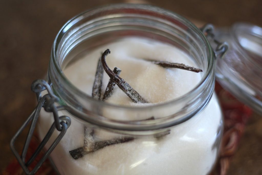 vanilla beans in sugar in a jar with the lid open